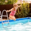 Niña saltando a piscina desmontable