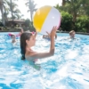 Familia jugando con pelota de playa en piscina desmontable